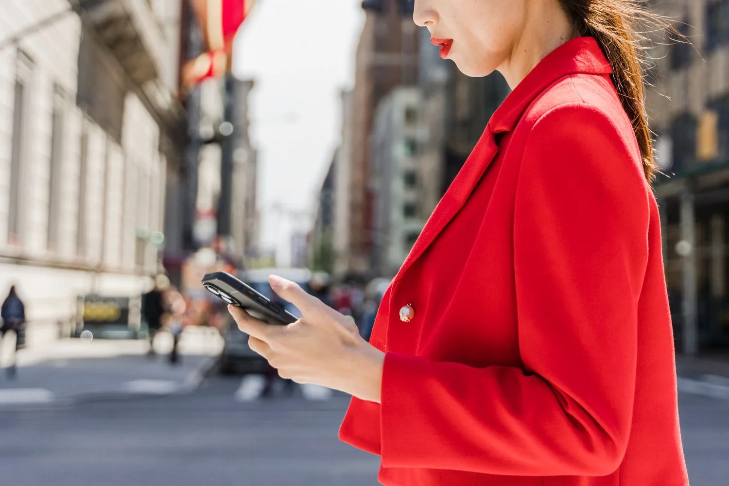 Persona consultando el móvil por la calle, en una zona comercial