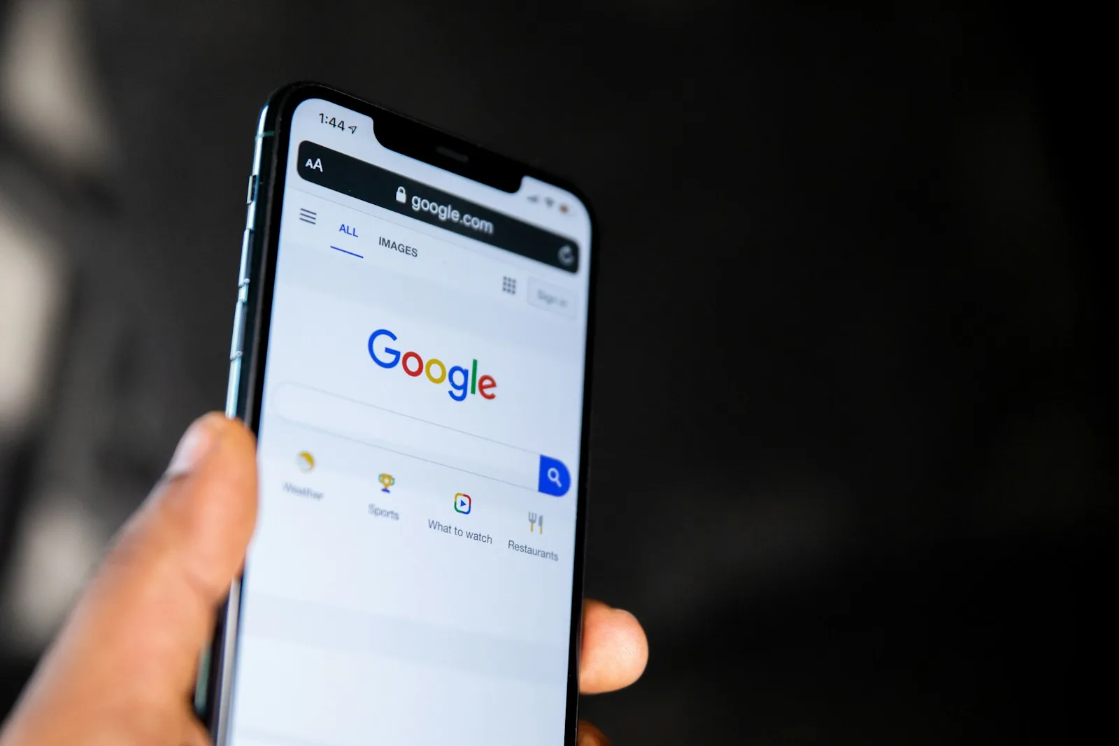 Mano sosteniendo un móvil con el buscador de Google abierto