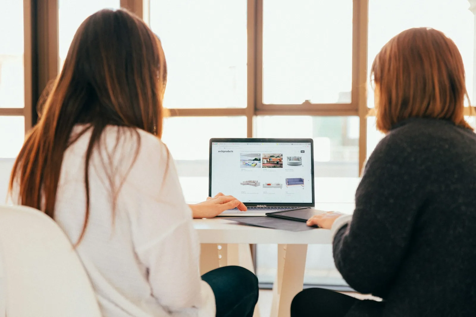 Dos personas revisando juntas el contenido de una página web en la pantalla de un ordenador